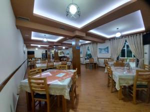 a restaurant with tables and chairs in a room at HOTEL KALEMI in Çorovodë