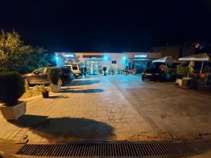 a parking lot in front of a store at night at HOTEL KALEMI in Çorovodë