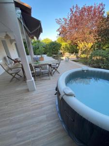 a hot tub on a deck with a table and chairs at appartement rez de villa proche port et plages de Sanary in Sanary-sur-Mer