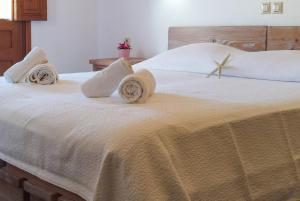 a bedroom with a large white bed with pillows at Mistral-Patmos in Patmos