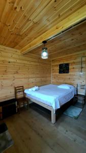 ein Schlafzimmer mit einem Bett in einer Holzhütte in der Unterkunft Chateau Dio in Ambrolauri
