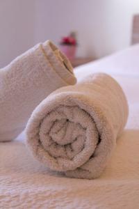 a rolled up towel on top of a bed at Mistral-Patmos in Patmos