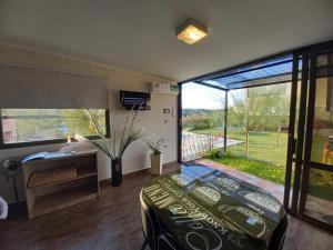 a bedroom with a bed and a desk and a large window at MIracampo in San Antonio de Arredondo