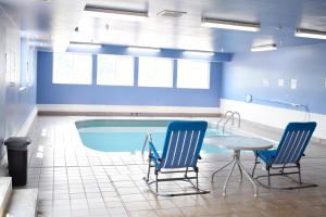 uma piscina com duas cadeiras e uma mesa num quarto em Days Inn by Wyndham Sioux City em Sioux City