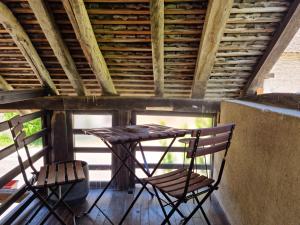 une table et deux chaises assises sur une terrasse couverte dans l'établissement Gite l'Escale, à Gigny-sur-Saône