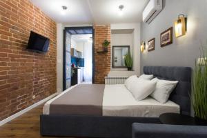 een slaapkamer met een bed en een bakstenen muur bij Cozy apartment in the Center - Podilskyi lane 7 in Charkov