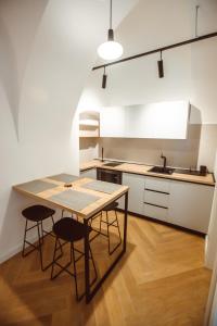 a kitchen with a table and chairs and a refrigerator at Sobe Merlon in Osijek