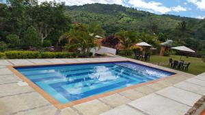 una piscina con una montagna sullo sfondo di Villa Maria Casa Campestre a San Gil