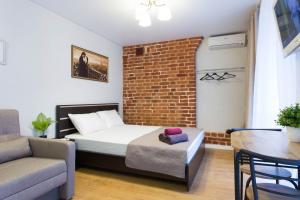 a bedroom with a bed and a brick wall at Cozy studio in the city center - Mayakovskogo str. 5-1 in Kharkiv