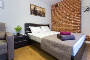 ein Schlafzimmer mit einem Bett und einer Ziegelwand in der Unterkunft Cozy studio in the city center - Mayakovskogo str. 5-1 in Kharkov