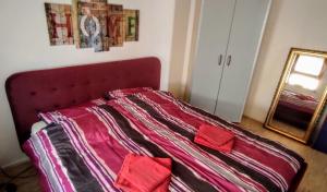a bed with a red headboard and a mirror at Stylische Ferienwohnung Home Office in Wiesbaden