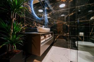 ein Bad mit einem Waschbecken und Pflanzen in der Unterkunft Luxury Rooms VINDEMIÆ in Zadar + 18 Fotos