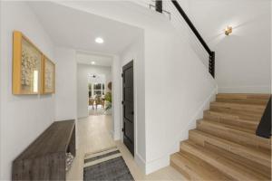 a hallway with a staircase with white walls and wooden floors at Our Great Escape home in Anna Maria