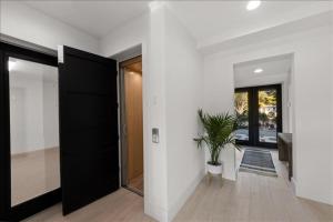 a hallway with a black door and a potted plant at Our Great Escape home in Anna Maria