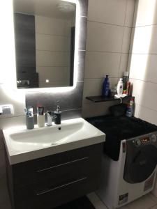 La salle de bains est pourvue d'un lavabo blanc et d'un miroir. dans l'établissement Apartament Moniuszki, à Kędzierzyn-Koźle
