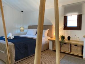 a bedroom with a bed with blue sheets and a window at Palma Seaside Villa 1 in Sarti