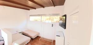 Cette petite chambre blanche dispose d'un lit et d'une fenêtre. dans l'établissement Loft Con Encanto, à Frontera