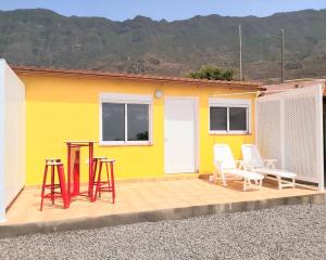 a yellow house with chairs and a table in front of it at Loft Con Encanto in Frontera
