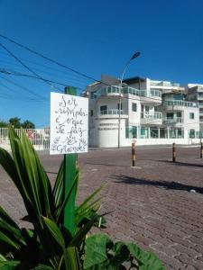 um sinal em frente a um grande edifício em Apartamento Elizabetta 3, pé na areia em Arraial do Cabo