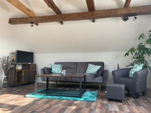 a living room with a couch and a table at Ferienwohnungen Lausbuben & Zicken - im grünen Herzen Deutschlands in Herleshausen