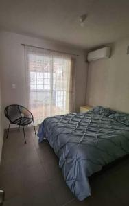 - une chambre avec un lit, une chaise et une fenêtre dans l'établissement El Arrecife: Apartamento con alberca a 10 minutos de la playa, à Acapulco