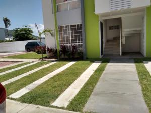un edificio verde y blanco con acera y césped en El Arrecife: Apartamento con alberca a 10 minutos de la playa, en Acapulco