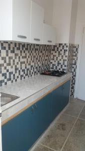 a kitchen with blue and white cabinets and a sink at Siwar in Rabat
