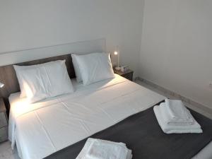 a large white bed with two white towels on it at Hanioti View Apartment in Hanioti