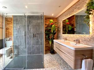 La salle de bains est pourvue d'une douche en verre et d'un lavabo. dans l'établissement Hambrook House Canterbury - NEW luxury guest house with ESPA Spa complex, à Canterbury