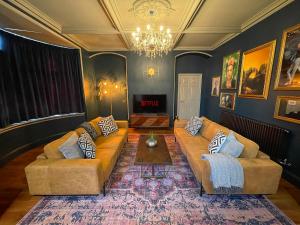 a living room with two couches and a chandelier at Selworthy - Luxury 3 Bedroom Apartment in Yeovil