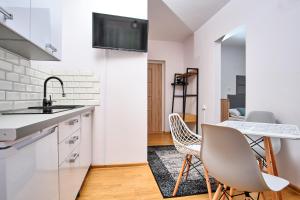 a kitchen with a sink and a table with chairs at Dom Wypoczynkowy LAGUNA Gąski in Gąski +55 photos