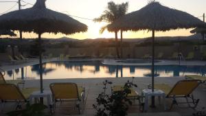 a pool with tables and chairs and umbrellas at Summer Days in Faliraki