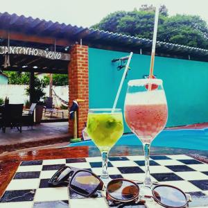 two glasses of wine sitting on a checkered table at Pousada Flores em Vida in Olímpia