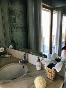 La salle de bains est pourvue d'un lavabo et d'un grand miroir. dans l'établissement Quinta de Santa Marinha, à Castedo