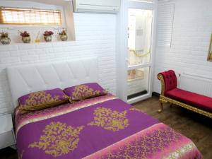 イスタンブールにあるIstanberry - Pera Apartmentsのベッドルーム(紫色のベッド1台、椅子付)