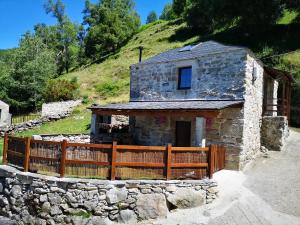 a stone house with a wooden fence in front of it at El Cuarto in Suarbol +15 photos