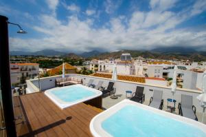 a balcony with two swimming pools on a roof at NERJA-CENTRO-JACUZZI- MIRADOR DE LA ERMITA- Adults Recommended in Nerja