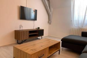 een woonkamer met een tv en een houten salontafel bij Sans-soucis en plein coeur d'Hautvillers in Hautvillers