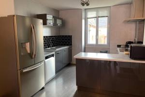 a kitchen with a stainless steel refrigerator and a sink at Sans-soucis en plein coeur d'Hautvillers in Hautvillers