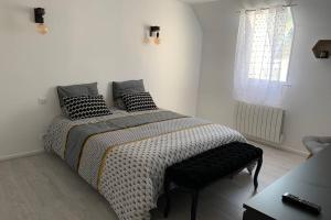 een slaapkamer met een bed met zwarte kussens erop bij Sans-soucis en plein coeur d'Hautvillers in Hautvillers