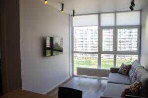 un soggiorno con divano e una grande finestra di Kokos Avenue Loft Apartments a Yuzhne