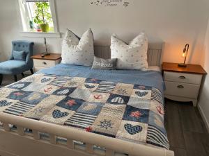 a bedroom with a bed with a quilt on it at Ferienwohnungen Lausbuben & Zicken - im grünen Herzen Deutschlands in Herleshausen