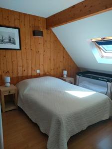 1 dormitorio con cama blanca y tragaluz en Appartement Duplex dans Résidence VAL DE ROLAND en Luz-Saint-Sauveur