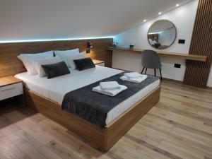 a bedroom with a large bed and a mirror at Sky Luxury in Arandjelovac