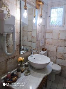 a bathroom with a sink and a toilet at Violetta Rooms in Koroni