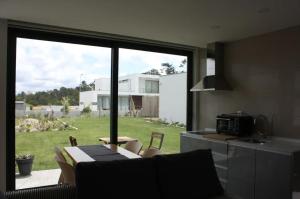 a kitchen with a large window and a table and chairs at AMARÉ Studio in Ovar
