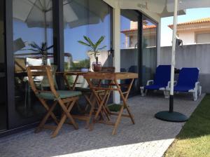 a table and chairs and an umbrella on a patio at AMARÉ Studio in Ovar +4 photos