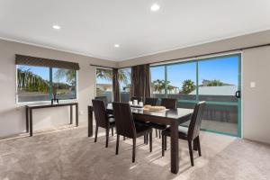 a dining room with a table and chairs at Ohope Palms - Ohope Holiday Home in Ohope Beach