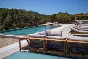 a swimming pool with lounge chairs next to a swimming pool at Borgo Lianti case vacanza Sardegna in San Pasquale