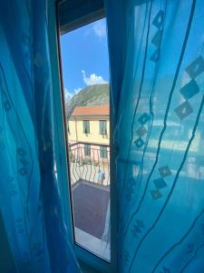 einen Blick aus einem Fenster mit einem blauen Vorhang in der Unterkunft Raggi di Sole in Monterosso al Mare